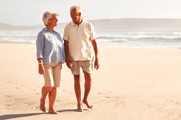 couple de retraité se baladant sur la plage